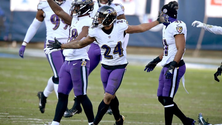 Baltimore Ravens cornerback Marcus Peters (24) and his teammates stomp on the Titans logo after Peters picked up an interception to seal their win over the Tennessee Titans in Nashville on January 10, 2021.