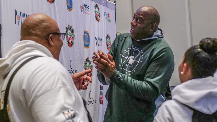 Earvin \"Magic\" Johnson talks with Union Missionary Baptist Church's pastor Kenny Craig, left, and his wife Corrie at Johnson's Holiday Hope for Families event held at the church Saturday, Nov. 11, 2023.