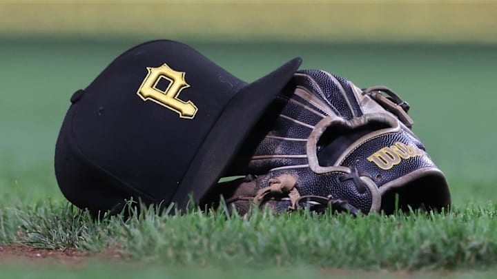 Sep 16, 2025; Pittsburgh, Pennsylvania, USA; A hat and glove belonging to Pittsburgh Pirates third baseman Jared Triolo (not pictured) on the field against the Chicago Cubs during the sixth inning at PNC Park. Mandatory Credit: Charles LeClaire-Imagn Images