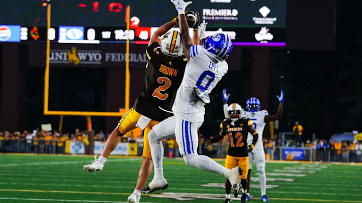 Sep 14, 2024; Laramie, Wyoming, USA; Wyoming Cowboys nose guard Wrook Brown (2) makes an interception against Brigham Young Cougars wide receiver Kody Epps (0) during the first quarter at Jonah Field at War Memorial Stadium. Mandatory Credit: Troy Babbitt-Imagn Images