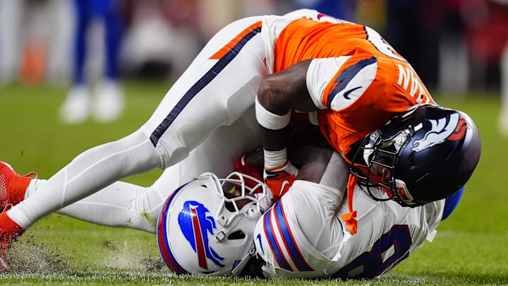 Denver Broncos cornerback Ja'quan McMillian (29) intercepts a pass intended for Buffalo Bills wide receiver Brandin Cooks (18) during overtime of an AFC Divisional Round playoff game at Empower Field at Mile High.