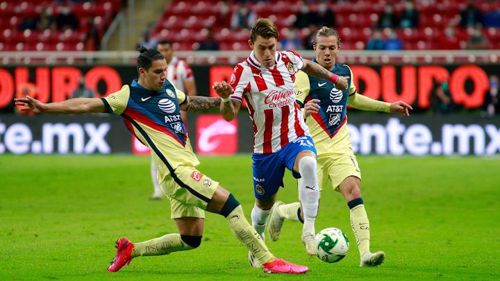 Cristian Calderón entre dos jugadores del América.