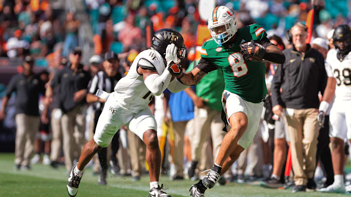Miami Hurricanes tight end Elijah Arroyo (8) runs with the football against Wake Forest Demon Deacons defensive back Davaughn Patterson (13) during the second quarter at Hard Rock Stadium. Mandatory Credit: Sam Navarro-Imagn Images