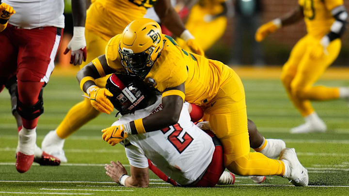 Oct 7, 2023; Waco, Texas, USA; Baylor Bears defensive lineman Brendan Bett (90) makes a sack against Texas Tech Red Raiders quarterback Behren Morton (2) during the second half at McLane Stadium. Mandatory Credit: Chris Jones-Imagn Images