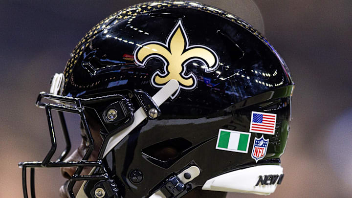 Sep 7, 2025; New Orleans, Louisiana, USA;  Detailed view of the helmet worn by New Orleans Saints safety Ugo Amadi (0) with and American Flag and the flag of Nigeria during warmups against the Arizona Cardinals at Caesars Superdome. Mandatory Credit: Stephen Lew-Imagn Images