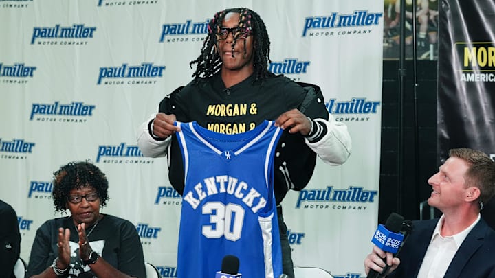 Jasper Johnson, a Lexington native and one of the top basketball players in the 2025 high school class, announces his commitment to the University of Kentucky during a ceremony at the Woodford County High School in Versailles, Ky. on Sep. 5, 2024. His grandmother Rosetta Johnson was at left and 247Sports analyst Travis Branham was at right.