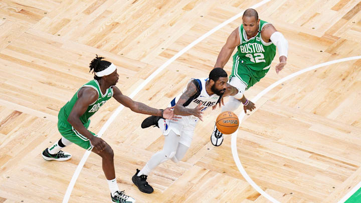 Jun 17, 2024; Boston, Massachusetts, USA; Dallas Mavericks guard Kyrie Irving (11) controls the ball against Boston Celtics guard Jrue Holiday (4) and center Al Horford (42) in the second quarter during game five of the 2024 NBA Finals at TD Garden. Mandatory Credit: David Butler II-Imagn Images