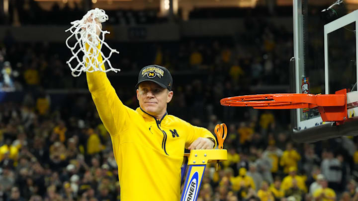 Apr 6, 2026; Indianapolis, IN, USA; Michigan Wolverines head coach Dusty May cuts down the net after defeating the Connecticut Huskies in the national championship of the Final Four of the men's 2026 NCAA Tournament at Lucas Oil Stadium. Mandatory Credit: Robert Deutsch-Imagn Images