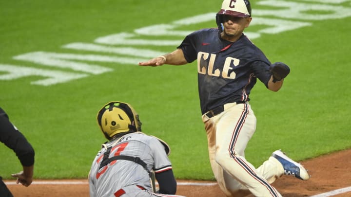 May 17, 2024; Cleveland, Ohio, USA; Cleveland Guardians second baseman Andres Gimenez (0) slides before being tagged out by Minnesota Twins catcher Ryan Jeffers (27) in the sixth inning at Progressive Field. Mandatory Credit: David Richard-USA TODAY Sports