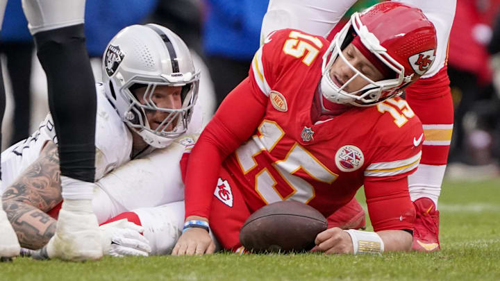 Dec 25, 2023; Kansas City, Missouri, USA; Kansas City Chiefs quarterback Patrick Mahomes (15) reacts after being sacked by Las Vegas Raiders defensive end Maxx Crosby (98) during the game at GEHA Field at Arrowhead Stadium. Mandatory Credit: Denny Medley-Imagn Images