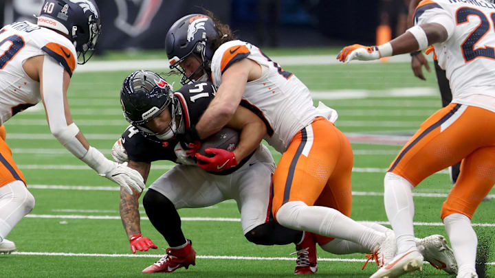 Nov 2, 2025; Houston, Texas, USA; Denver Broncos linebacker Alex Singleton (49) tackles Houston Texans wide receiver Jaylin Noel (14 during the second half at NRG Stadium. Mandatory Credit: Thomas Shea-Imagn Images