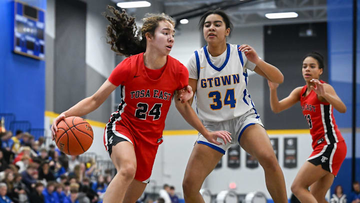 Wauwatosa East guard Mikaia Litza (24) drives to the basket past Germantown guard Morgan Johnson (34) in a Greater Metro Conference game Friday, December 5, 2025. Wauwatosa East guard Mikaia Litza (24) drives to the basket past Germantown guard Morgan Johnson (34) in a Greater Metro Conference game Friday, December 5, 2025.