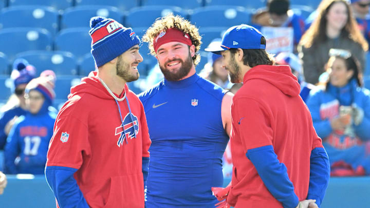 Nov 3, 2024; Orchard Park, New York, USA; Buffalo Bills quarterback Mitchell Trubisky (left) tight end Dawson Knox (center) and quarterback Josh Allen (right) have a discussion before a game against the Miami Dolphins at Highmark Stadium. Mandatory Credit: Mark Konezny-Imagn Images