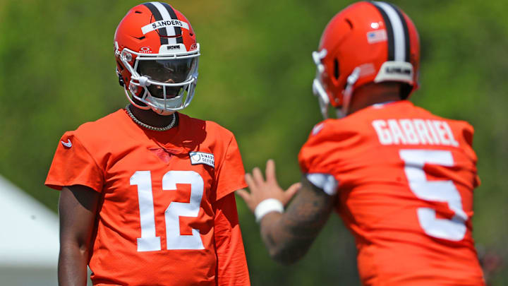 Cleveland Browns quarterback Shedeur Sanders (12) watches quarterback Dillon Gabriel (5) during day two of NFL rookie minicamp at the Cleveland Browns training facility.