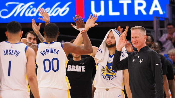 Golden State Warriors forward Jonathan Kuminga high fives guard Stephen Curry at Chase Center. 