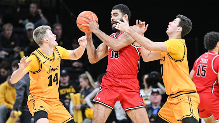 Nov 18, 2025; Iowa City, Iowa, USA; Southeast Missouri State Redhawks center David Idada (18) is defended by Iowa Hawkeyes guard Bennett Stirtz (14) and forward Alvaro Folgueiras (7) during the second half at Carver-Hawkeye Arena. Mandatory Credit: Jeffrey Becker-Imagn Images Nov 18, 2025; Iowa City, Iowa, USA; Southeast Missouri State Redhawks center David Idada (18) is defended by Iowa Hawkeyes guard Bennett Stirtz (14) and forward Alvaro Folgueiras (7) during the second half at Carver-Hawkeye Arena. Mandatory Credit: Jeffrey Becker-Imagn Images