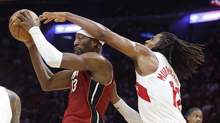 Dec 23, 2025; Miami, Florida, USA;  Toronto Raptors forward Collin Murray-Boyles (12) defends Miami Heat center Bam Adebayo (13) during the second half at Kaseya Center. Mandatory Credit: Rhona Wise-Imagn Images