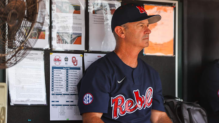 Jun 26, 2022; Omaha, NE, USA; Ole Miss Head Coach Mike Bianco sits in the dugout just before the first inning against the Oklahoma Sooners at Charles Schwab Field. Mandatory Credit: Jaylynn Nash-Imagn Images