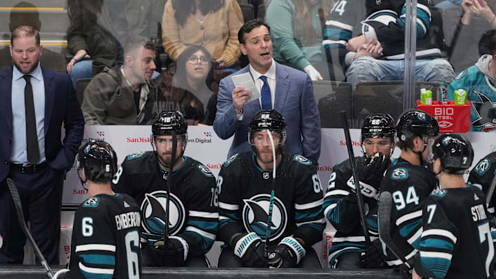 Feb 17, 2024; San Jose, California, USA; San Jose Sharks head coach David Quinn (center) talks to