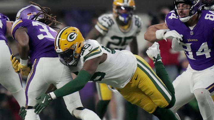 Green Bay Packers linebacker Edgerrin Cooper (56) tackles Minnesota Vikings running back Aaron Jones for a loss.