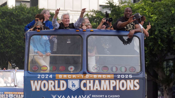 Nov 3, 2025; Los Angeles, CA, USA;  Los Angeles Dodgers owners Mark Walter and Magic Johnson wave to fans during the World Series championship parade and celebration. Mandatory Credit: Kirby Lee-Imagn Images