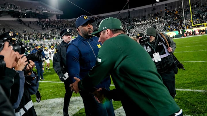 Michigan State's head coach Jonathan Smith, right, shakes hands with Michigan's head coach Sherrone Moore after the game on Saturday, Oct. 25, 2025, at Spartan Stadium in East Lansing.