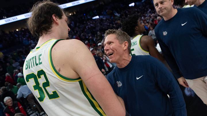 Oregon’s Nate Bittle, left, meets Gonzaga coach Mark Few courtside after the Northwest Elite Showdown game at the Moda Center in Portland Dec. 21, 2025.