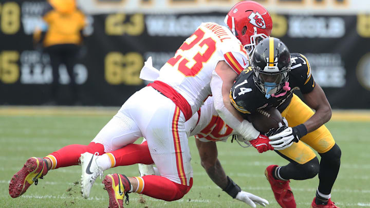 Dec 25, 2024; Pittsburgh, Pennsylvania, USA;  Pittsburgh Steelers wide receiver George Pickens (14) is tackled after a catch by Kansas City Chiefs linebacker Drue Tranquill (23) and safety Justin Reid (20) during the second quarter at Acrisure Stadium. Mandatory Credit: Charles LeClaire-Imagn Images