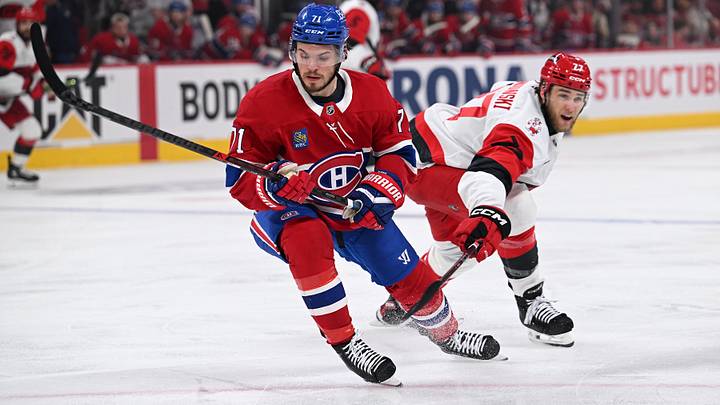 May 27, 2026; Montreal, Quebec, CAN; Montreal Canadiens center Jake Evans (71) skates with the puck past Carolina Hurricanes left wing Mark Jankowski (77) during the second period in game four of the Eastern Conference Final of the 2026 Stanley Cup Playoffs at Bell Centre. Mandatory Credit: David Kirouac-Imagn Images