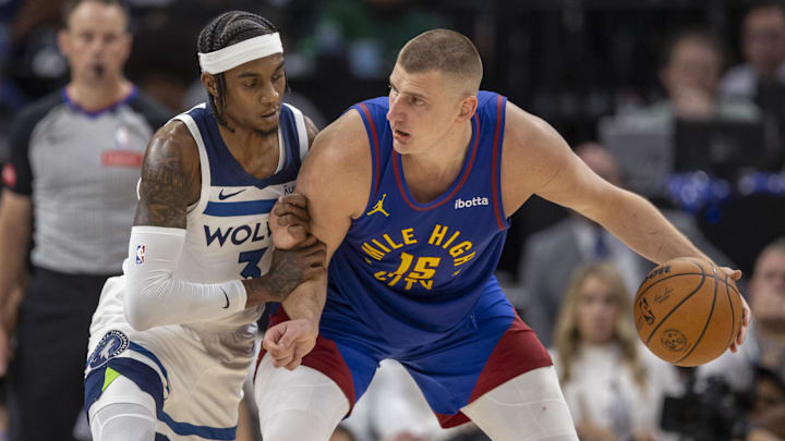 Denver Nuggets center Nikola Jokic (15)  backs in on ex-Husky Jaden McDaniels. 