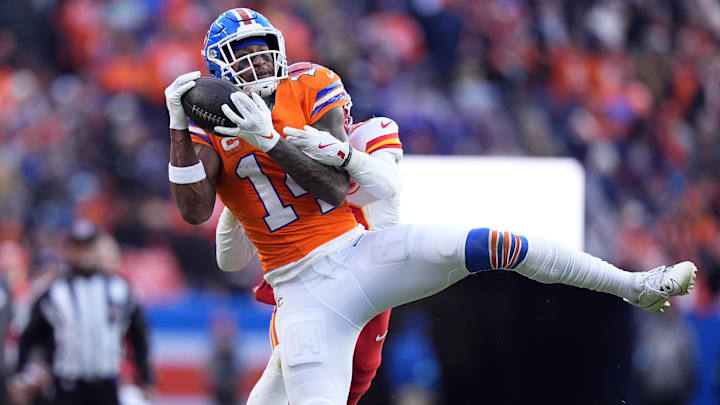 Jan 5, 2025; Denver, Colorado, USA; Denver Broncos wide receiver Courtland Sutton (14) pulls in a reception past Kansas City Chiefs safety Nazeeh Johnson (13) in the second quarter at Empower Field at Mile High. 