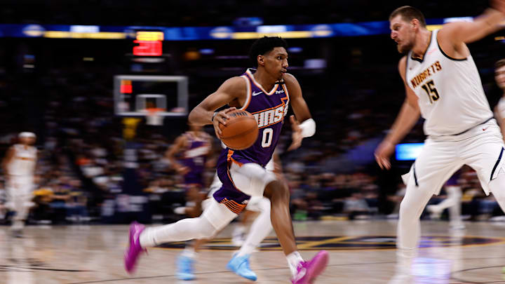 Oct 13, 2024; Denver, Colorado, USA; Phoenix Suns forward Ryan Dunn (0) controls the ball as Denver Nuggets center Nikola Jokic (15) defends in the second quarter at Ball Arena. Mandatory Credit: Isaiah J. Downing-Imagn Images