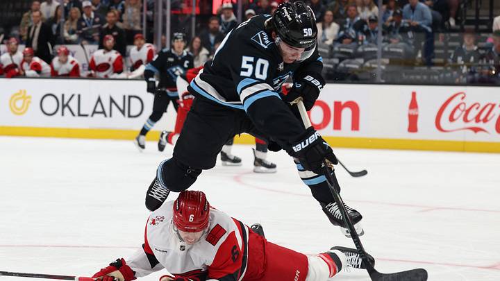 Apr 11, 2026; Salt Lake City, Utah, USA; Utah Mammoth defenseman Sean Durzi (50) leaps over Carolina Hurricanes defenseman Mike Reilly (6) during the first period at Delta Center. Mandatory Credit: Rob Gray-Imagn Images