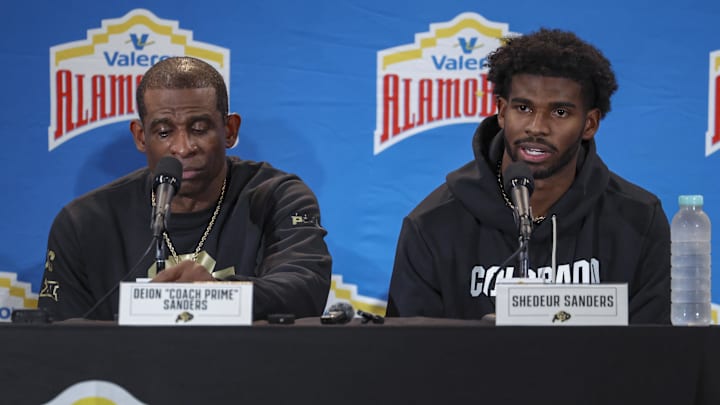 Dec 28, 2024; San Antonio, TX, USA; Colorado Buffaloes head coach Deion Sanders and quarterback Shedeur Sanders (2) talk with the media after the game against the Brigham Young Cougars at Alamodome. Mandatory Credit: Troy Taormina-Imagn Images