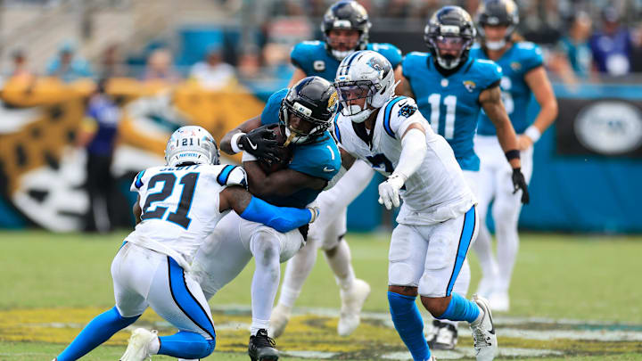 Jacksonville Jaguars running back Travis Etienne Jr. (1), center, rushes for yards against Carolina Panthers safety Nick Scott (21), left, and safety Tre'von Moehrig (7) during the fourth quarter of an NFL football matchup at EverBank Stadium, Sunday, Sept. 7, 2025 in Jacksonville, Fla. The Jaguars defeated the Panthers 26-10. [Corey Perrine/Florida Times-Union]