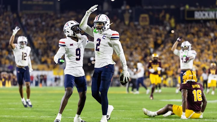 Nov 28, 2025; Tempe, Arizona, USA; Arizona Wildcats defensive back Treydan Stukes (2) celebrates with defensive back Ayden Garnes (9) after an interception against Arizona State Sun Devils in the second half during the 99th Territorial Cup at Mountain America Stadium. Mandatory Credit: Mark J. Rebilas-Imagn Images