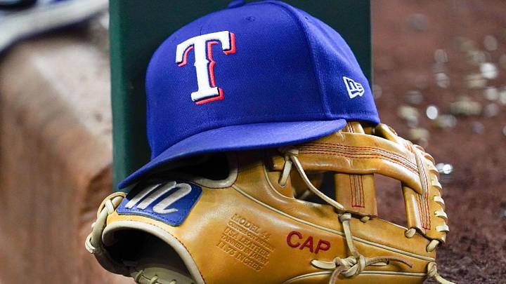 A Texas Rangers cap and baseball mitt. A Texas Rangers cap and baseball mitt.