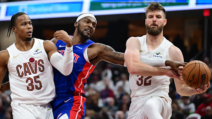Oct 25, 2024; Cleveland, Ohio, USA; Cleveland Cavaliers forward Dean Wade (32) goes for a rebound against Detroit Pistons forward Paul Reed (7) as forward Isaac Okoro (35) also defends during the first half at Rocket Mortgage FieldHouse. Mandatory Credit: Ken Blaze-Imagn Images
