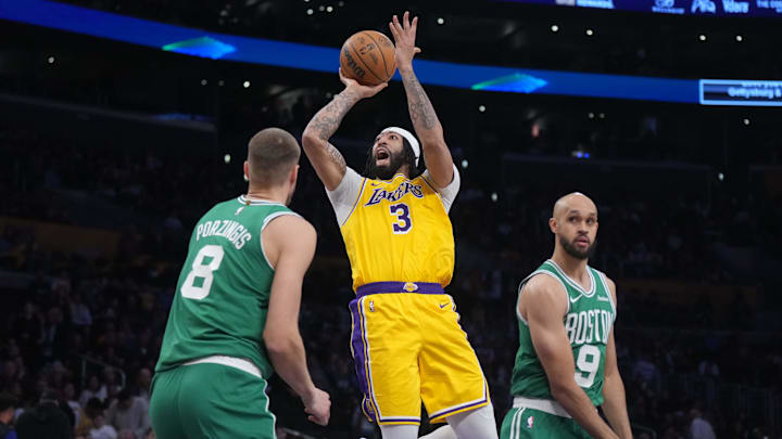 Jan 23, 2025; Los Angeles, California, USA; Los Angeles Lakers center Anthony Davis (3) shoots the ball against Boston Celtics center Kristaps Porzingis (8) and guard Derrick White (9) in the second half at the Crypto.com Arena. Mandatory Credit: Kirby Lee-Imagn Images