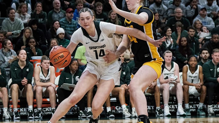 Michigan State's Grace VanSlooten (14) drives along the baseline past Iowa's Addison Grady (44) Sunday, Dec. 15, 2024 at the Breslin Center.