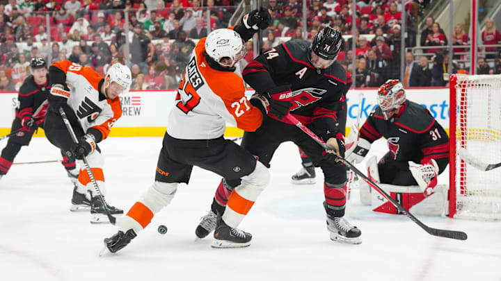 May 4, 2026; Raleigh, North Carolina, USA; Carolina Hurricanes defenseman Jaccob Slavin (74) and Philadelphia Flyers left wing Noah Cates (27) battle over the puck in the first overtime in game two of the second round of the 2026 Stanley Cup Playoffs at Lenovo Center. 