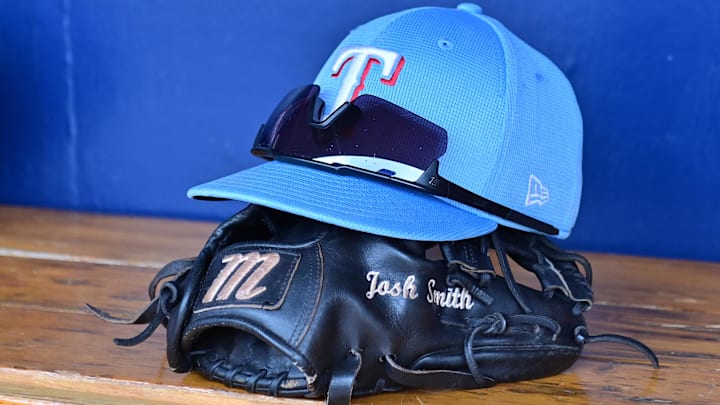 General view of a Texas Rangers hat, glove, and glasses prior to a spring training game against the Colorado Rockies at Salt River Fields at Talking Stick. General view of a Texas Rangers hat, glove, and glasses prior to a spring training game against the Colorado Rockies at Salt River Fields at Talking Stick.