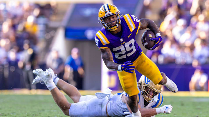 Sep 21, 2024; Baton Rouge, Louisiana, USA; UCLA Bruins linebacker Carson Schwesinger (49) misses a tackle against LSU Tigers running back Caden Durham (29) during the second half at Tiger Stadium. Mandatory Credit: Stephen Lew-Imagn Images Sep 21, 2024; Baton Rouge, Louisiana, USA; UCLA Bruins linebacker Carson Schwesinger (49) misses a tackle against LSU Tigers running back Caden Durham (29) during the second half at Tiger Stadium. Mandatory Credit: Stephen Lew-Imagn Images