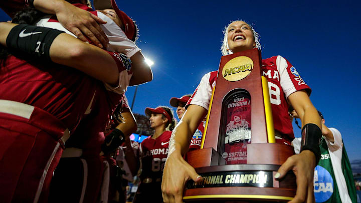 Oklahoma pitcher Alex Storako (8) holds the national championship trophy after OU won the Women's College World Series finals between Oklahoma (OU) and Florida State at USA Softball Hall of Fame Stadium in Oklahoma City on Thursday, June 8, 2023.