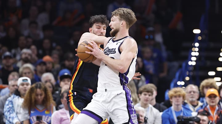 Feb 11, 2024; Oklahoma City, Oklahoma, USA; Sacramento Kings forward Domantas Sabonis (10) moves the ball against Oklahoma City Thunder forward Chet Holmgren (7) during the second half at Paycom Center. Mandatory Credit: Alonzo Adams-Imagn Images