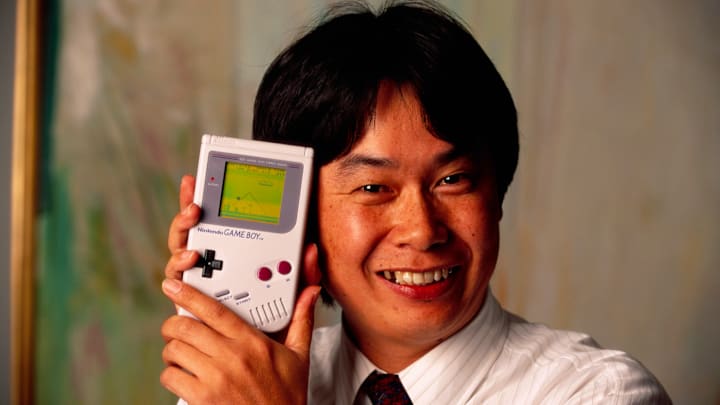 Video game designer Shigeru Miyamoto cradles a Game Boy.