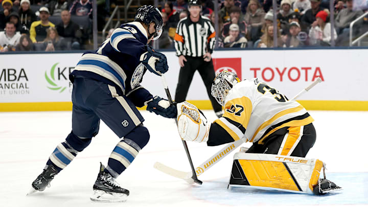 Blue Jackets F Danton Heinen tries to deflect a shot past Penguins G Arturs Silovs.