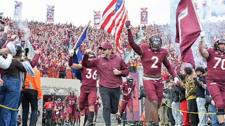 Nov 9, 2024; Virginia Tech head coach Brent Pry leads his team onto the field with wide receiver Takye Heath (2) before the game. Nov 9, 2024; Virginia Tech head coach Brent Pry leads his team onto the field with wide receiver Takye Heath (2) before the game.