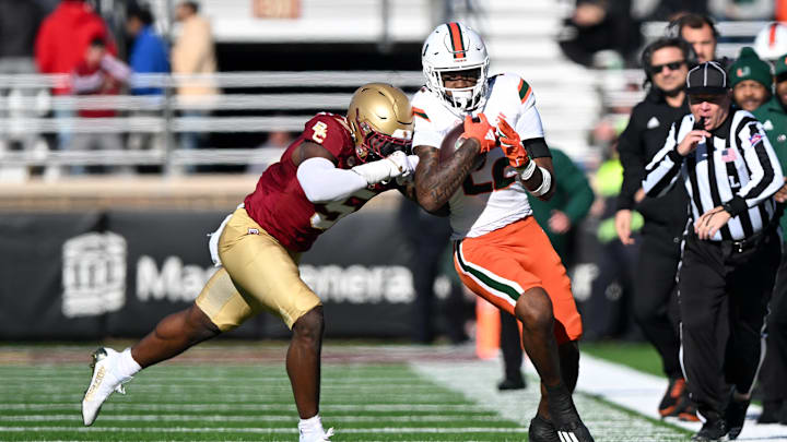 Nov 24, 2023; Chestnut Hill, Massachusetts, USA; Miami Hurricanes running back Mark Fletcher Jr. (22) runs against Boston College Eagles linebacker Kam Arnold (5) during the first half at Alumni Stadium. Mandatory Credit: Brian Fluharty-Imagn Images