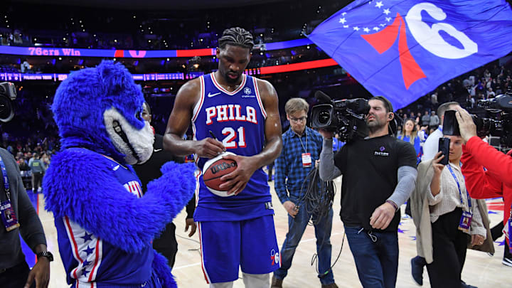 Apr 2, 2024; Philadelphia, Pennsylvania, USA; Philadelphia 76ers center Joel Embiid (21) autographs a basketball as he celebrates win against the Oklahoma City Thunder at Wells Fargo Center. Mandatory Credit: Eric Hartline-Imagn Images